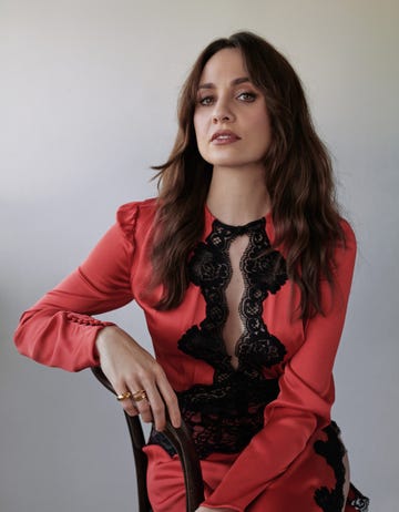 fashion model posing in a red dress with black lace detailing