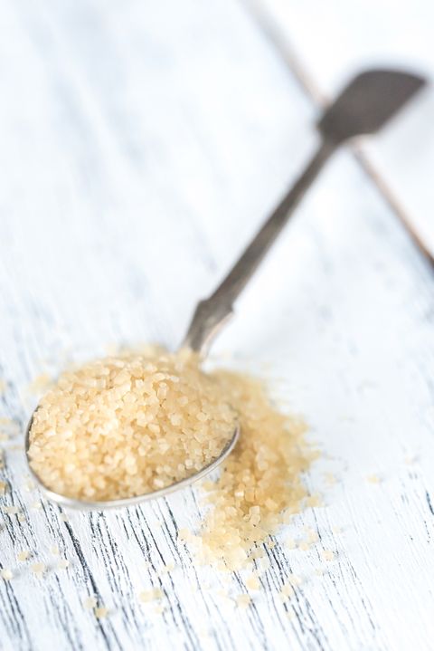 spoon of brown sugar on the wooden background