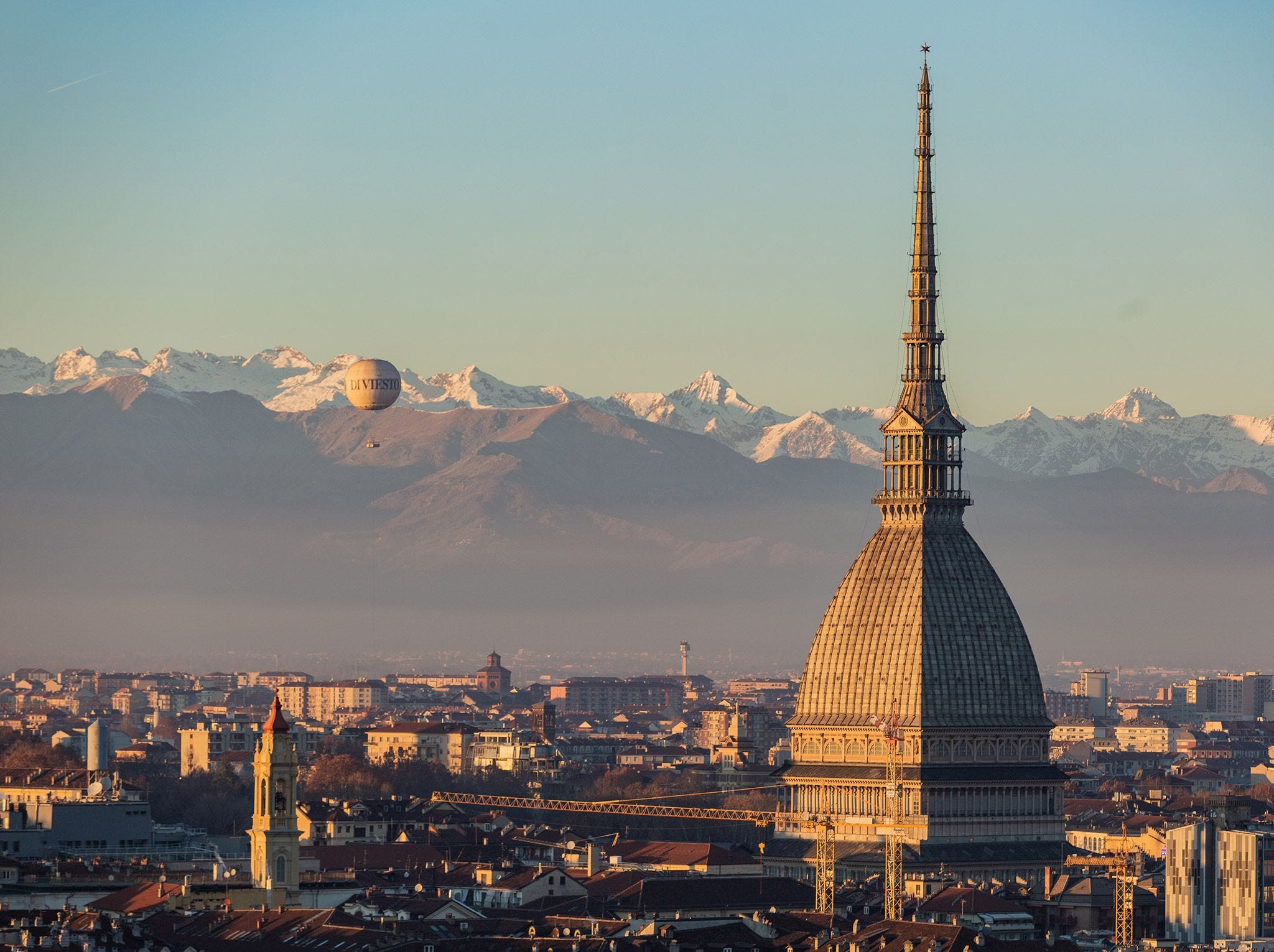 in turijn zweeft een heteluchtballon naast de mole antonelliana een van de hoogste bakstenen gebouwen in europa