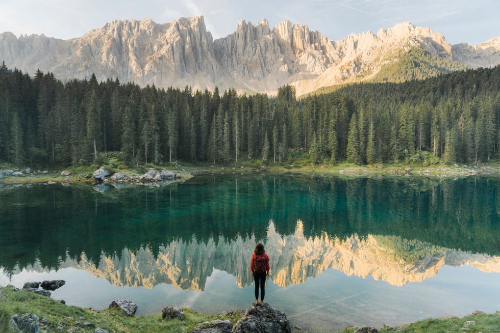 mujer ante el lago di carezza en los dolomitas