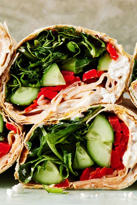 wrap filled with turkey, spinach, avocado, red peppers, and a goat cheese spread