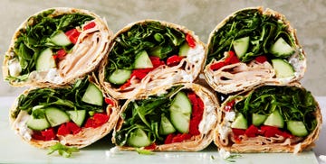 wrap filled with turkey, spinach, avocado, red peppers, and a goat cheese spread