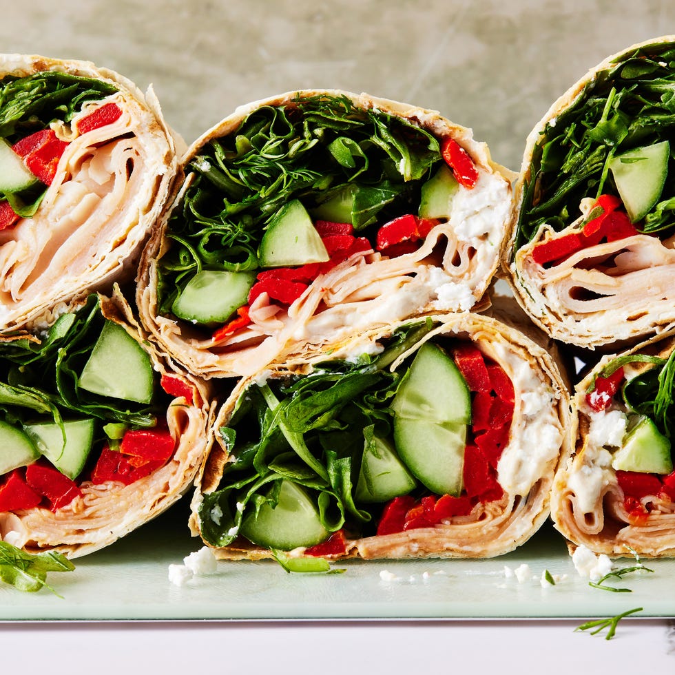 wrap filled with turkey, spinach, avocado, red peppers, and a goat cheese spread