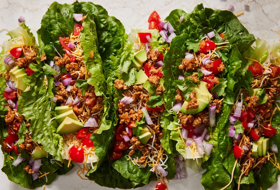 turkey taco lettuce wraps topped with cilantro, red onion, avocado, and tomatoes
