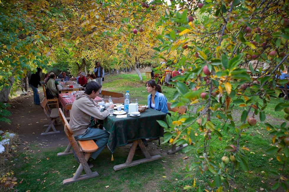 Gids Ugur nal en Daphne genieten van een lunch in de weelderige tuin van Cappadocia Restaurant in de Soganlivallei