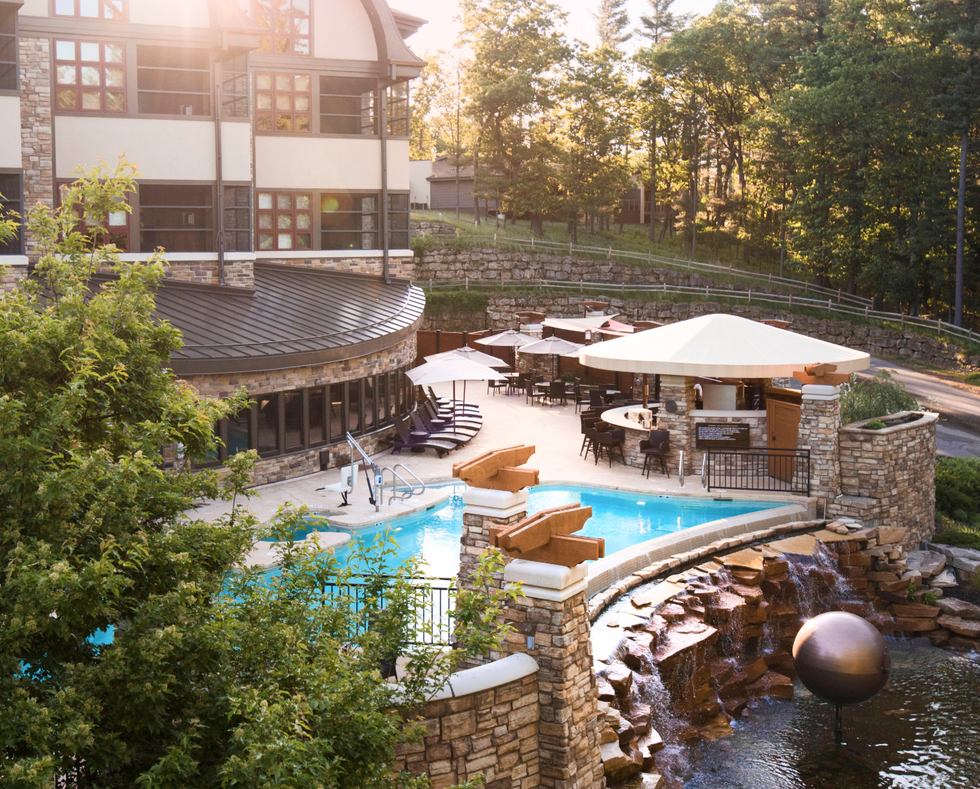 Pool with chairs and umbrellas near the building