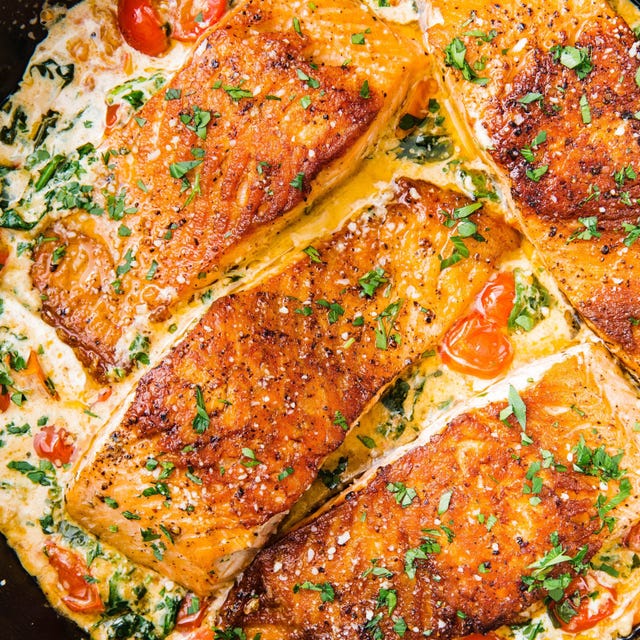 seared salmon fillets served with creamy sauce and vegetables