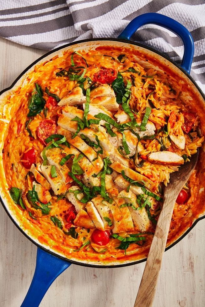 creamy tuscan butter chicken orzo in a blue dutch oven