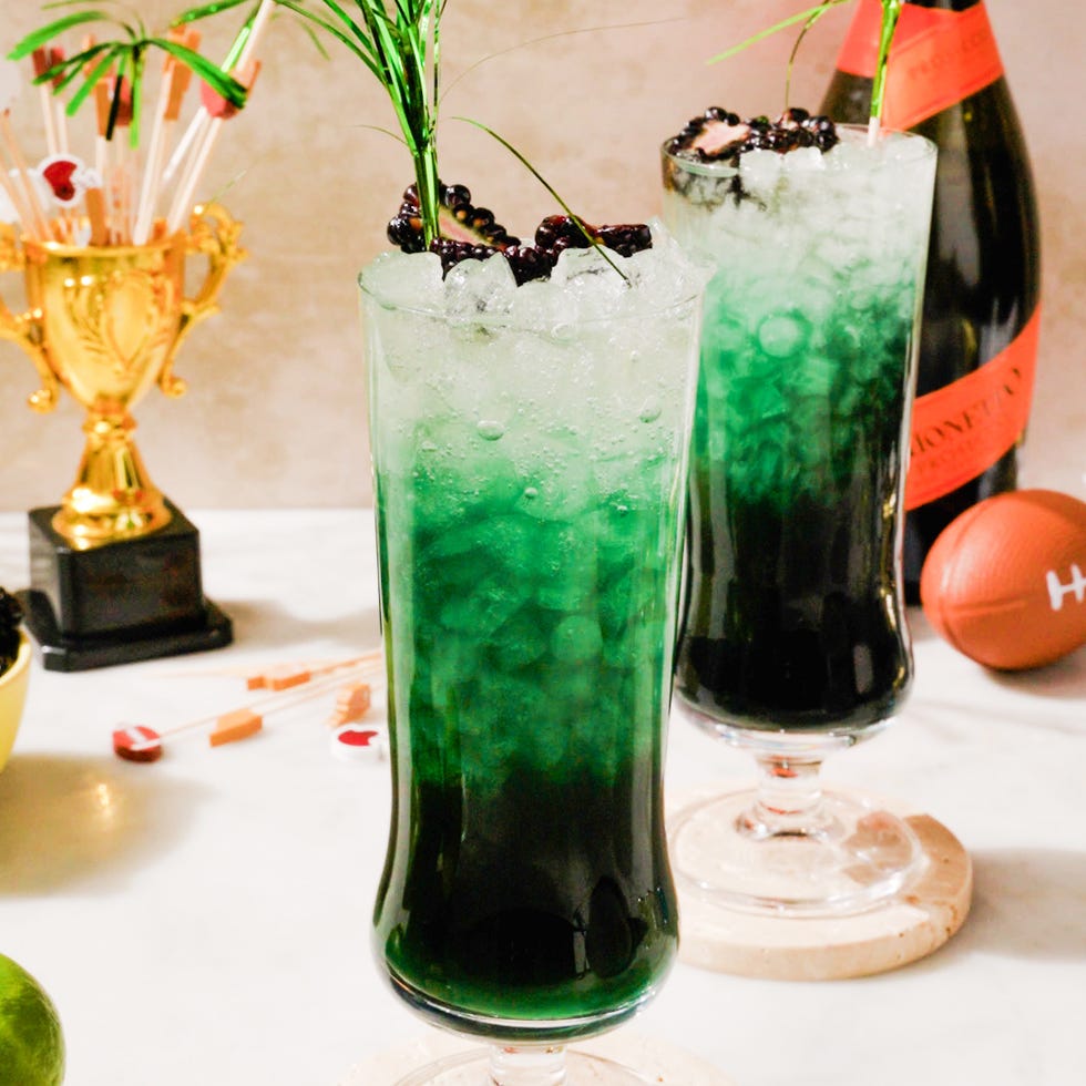 cocktails with ice and decorative garnishes featuring a sportsthemed backdrop