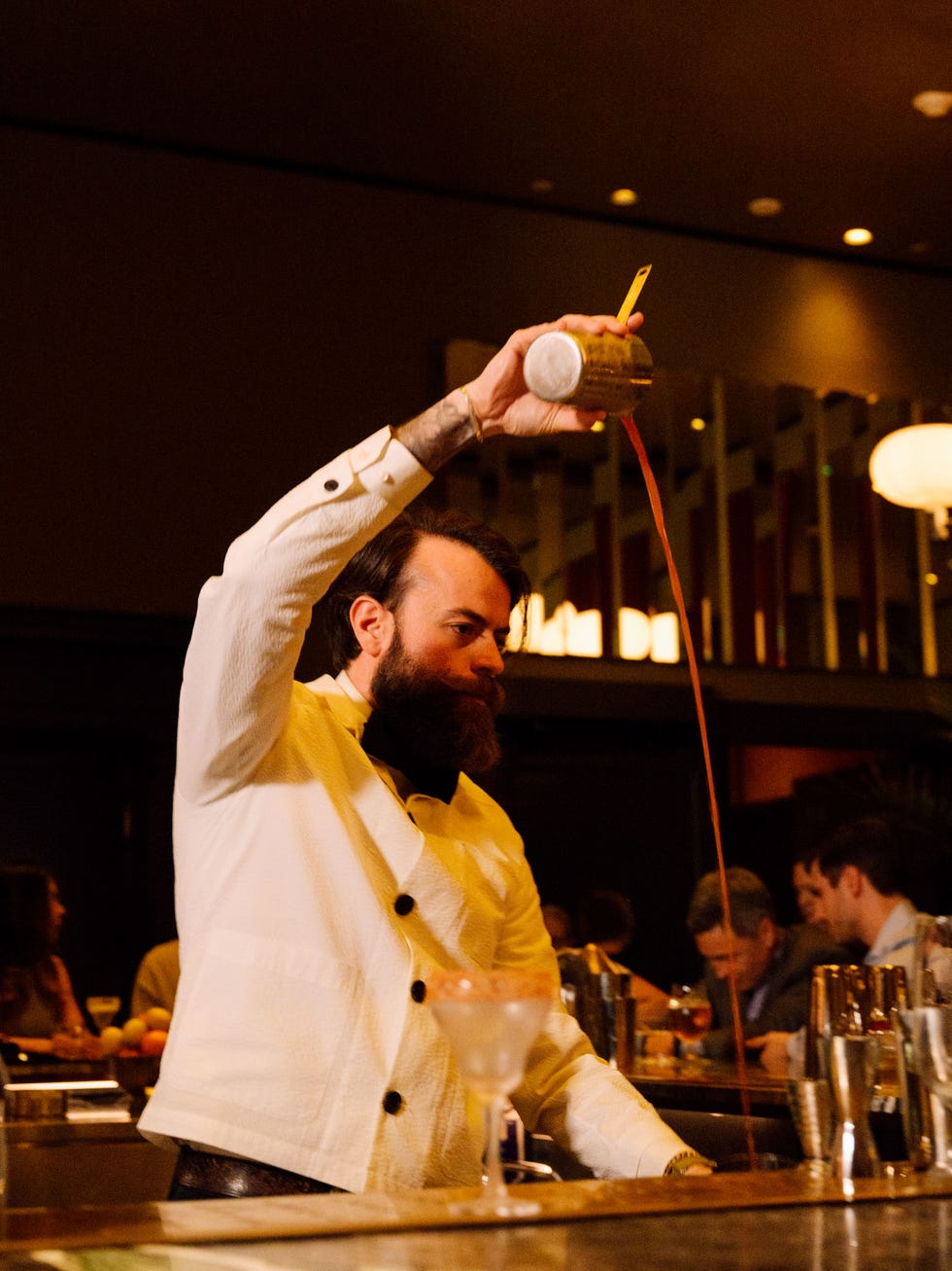 a man pouring a drink into a glass