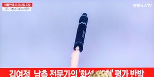 a tv screen shows a file image of north korea's missile