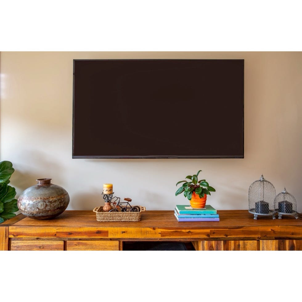 living room setup with a tv mounted on the wall and a wooden console table