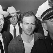 lee harvey oswald being led by policemen