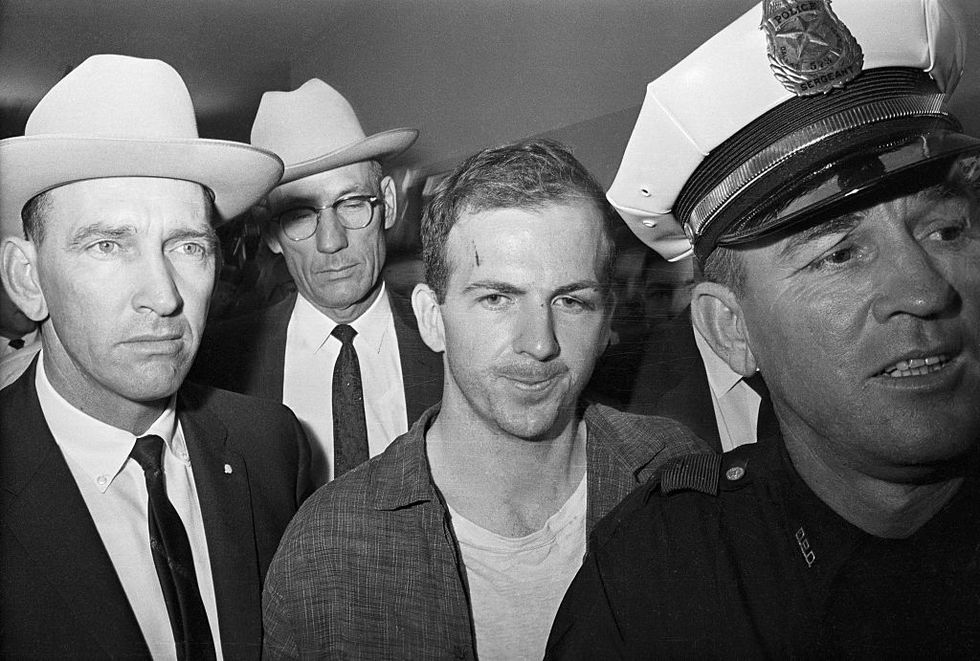 lee harvey oswald being led by policemen