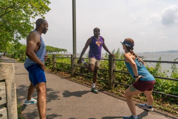runners stretching by river