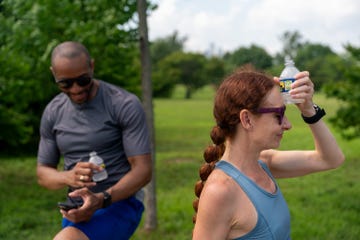 runner holding cold water to her head after workout