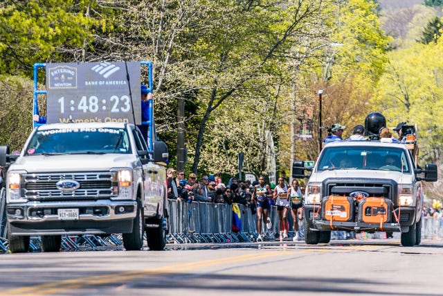 Scene from a marathon with vehicles and runners