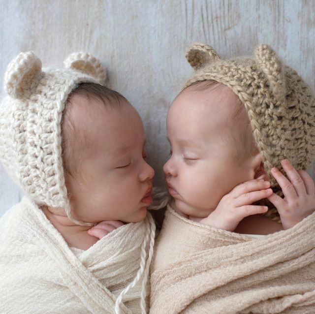 baby girls sleeping they are wearing crocheted bear hats and are swaddled in cream and tan wraps
