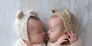 baby girls sleeping they are wearing crocheted bear hats and are swaddled in cream and tan wraps