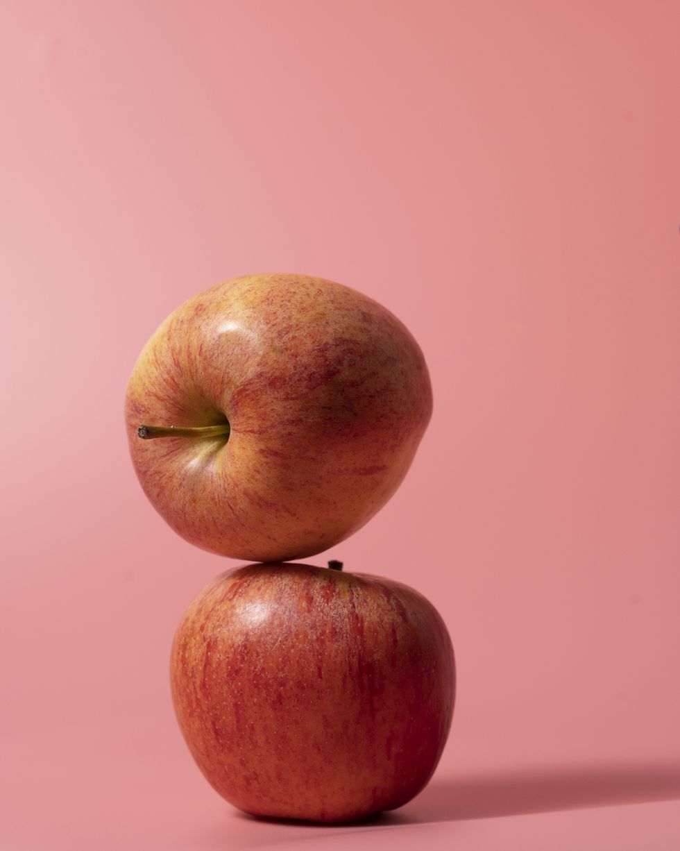 two apples on pink background