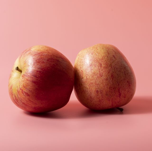 two apples on pink background