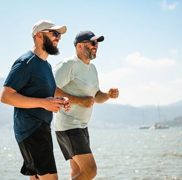 two best friends walking and doing sports on the beach