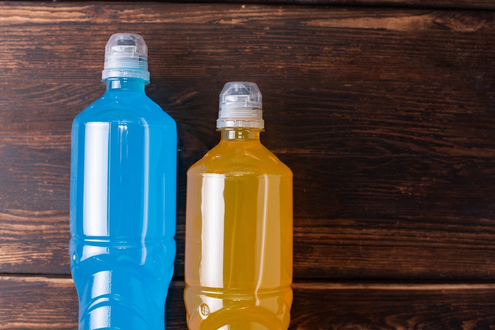 two bottles of orange and blue on a dark wooden background, restoring water and salt balance after sports training