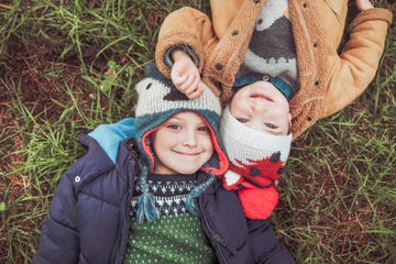 dos niños con ropa de invierno en la hierba