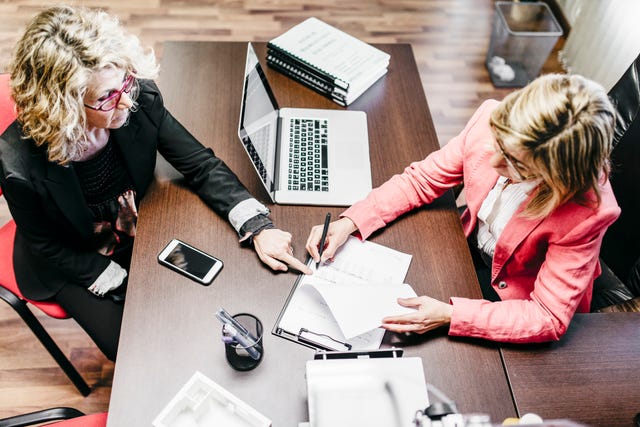 Two businesswomen working on document in office