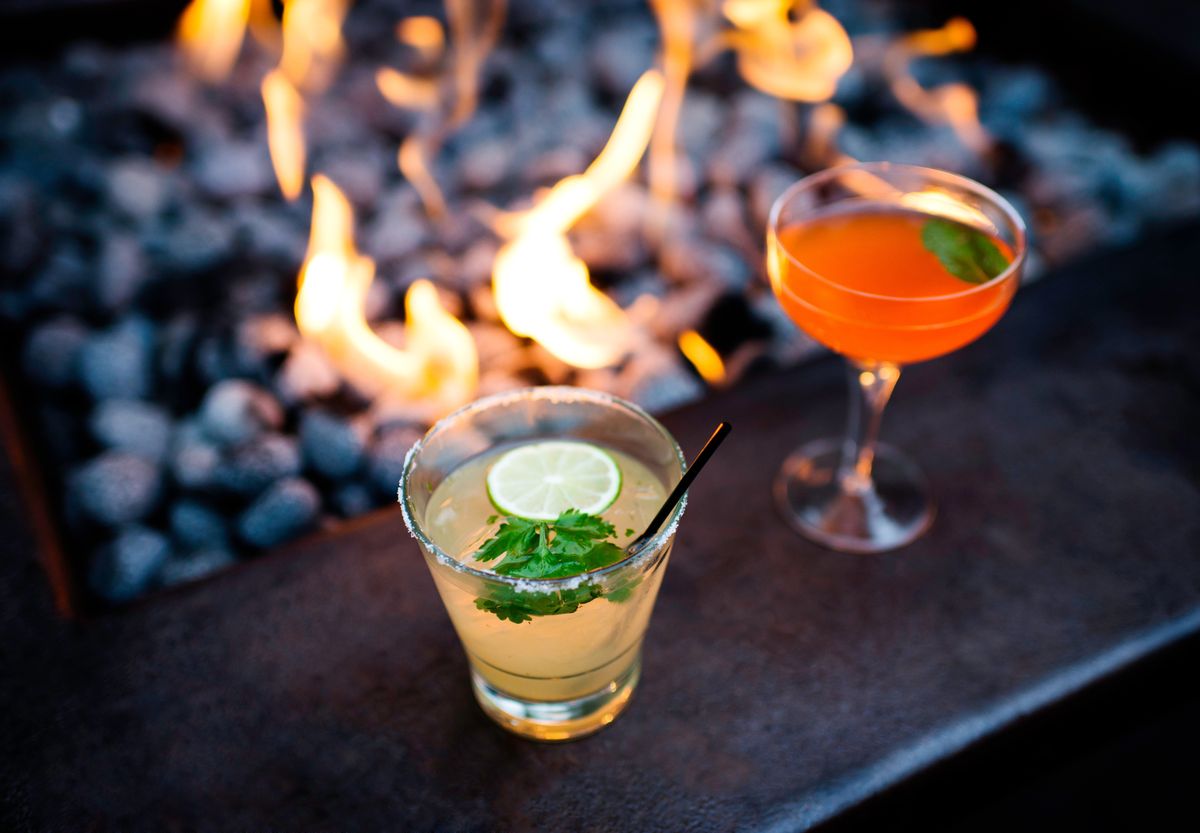 two cocktails by restaurant open fire
