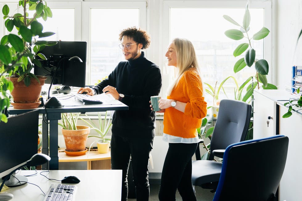 two colleagues looking at work using standing desk