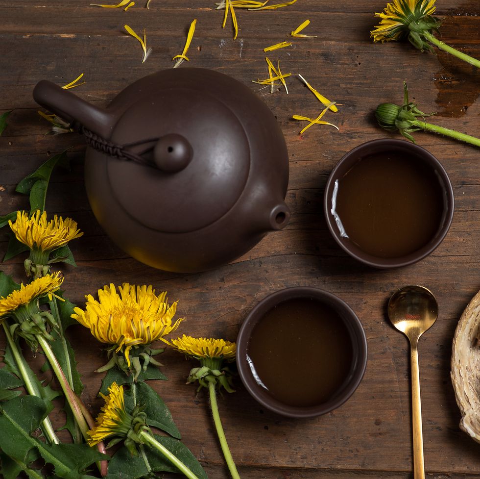 two cups of dandelion tea with dandelion herb leaf, flower and root