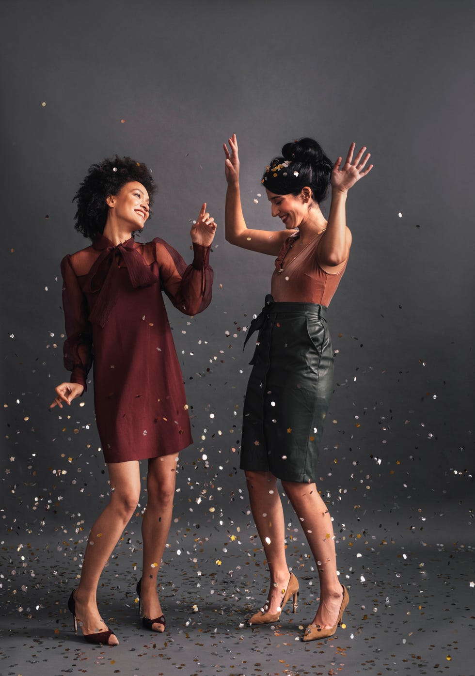 dancing in confetti two elegant women dancing together at a party studio shot, copy space