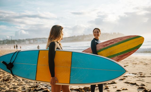 two female friends with surfboards