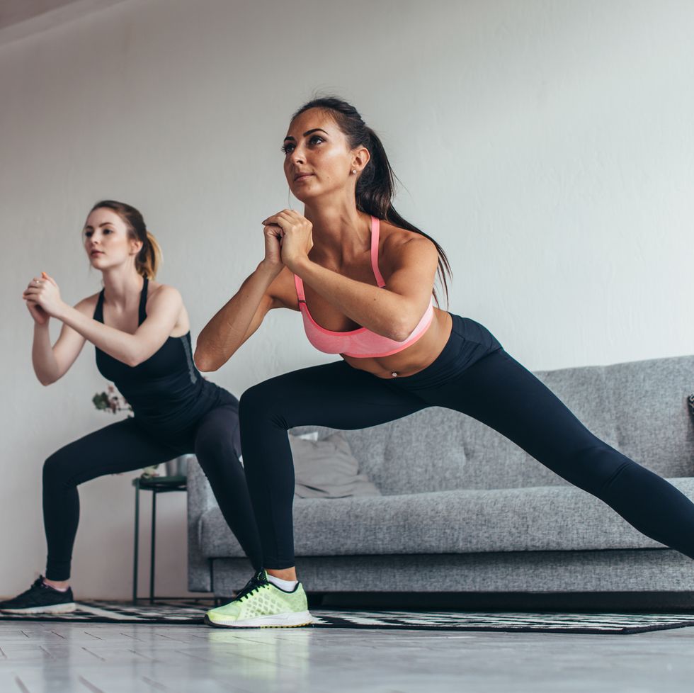 two fit girls doing home workout performing lateral lunges at home