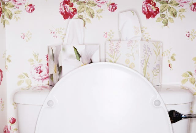 Two flower patterned tissue boxes on toilet with lid open