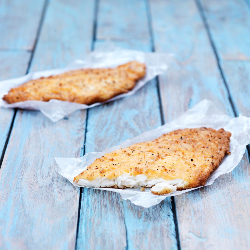 Two fried breaded flounder fish pieces on wooden table two fried breaded flounder fish pieces on wooden table