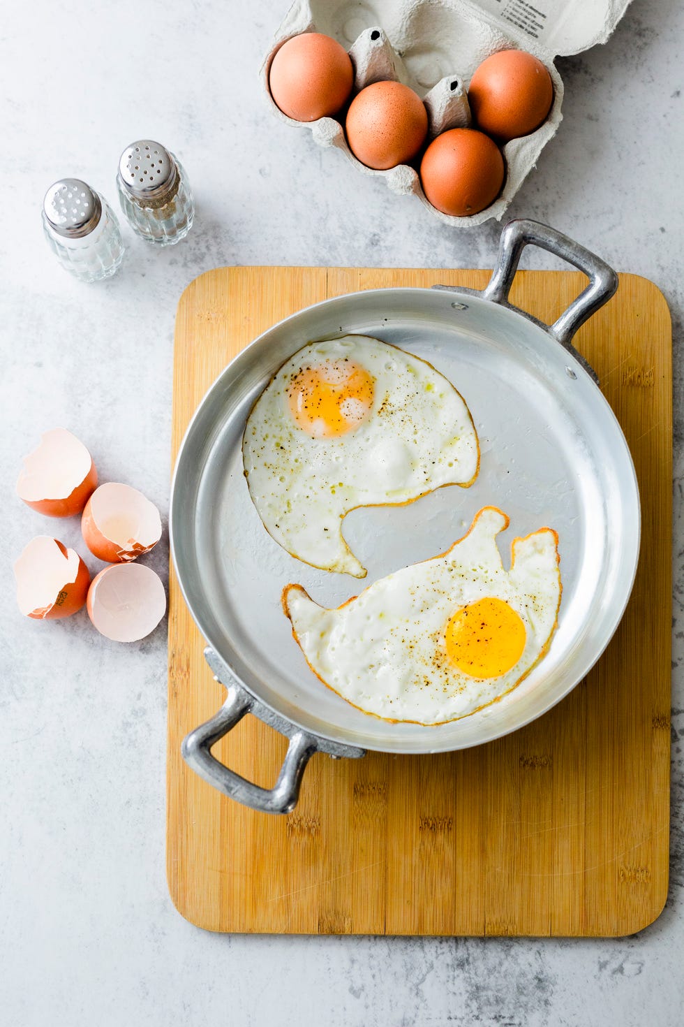 Two fried eggs with pepper in pan