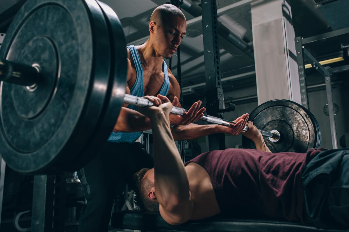 Working muscle. Тренировка в зале. Силовые тренировки. Мужчина тренируется в зале. Спортсмены в тренажерном зале.