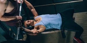 two friends exercising bench press in gym