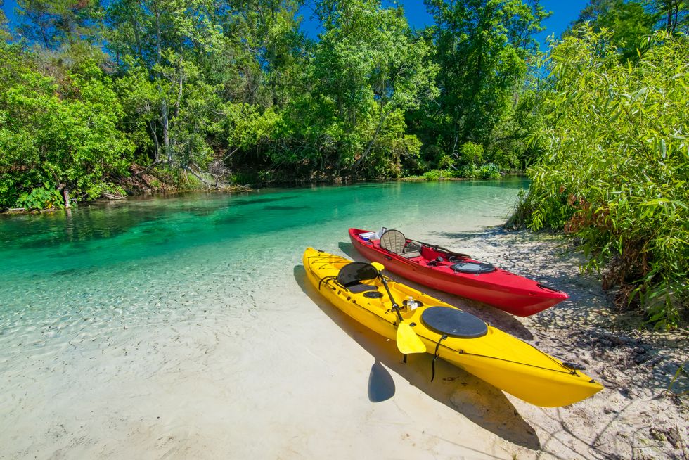 two kayaks on sandy river bank
