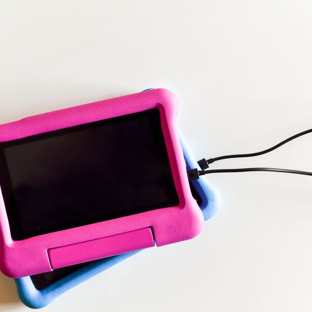 two kids tablet devices to play games and educational apps plugged in to power supply cable