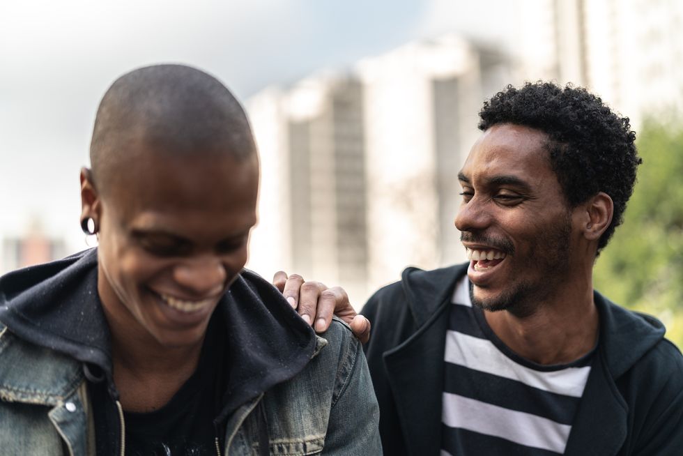two latino african male friends laughing