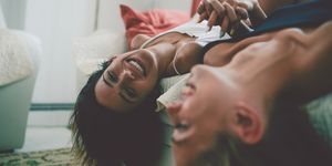 Twee lachende lesbische vrouwen op bed