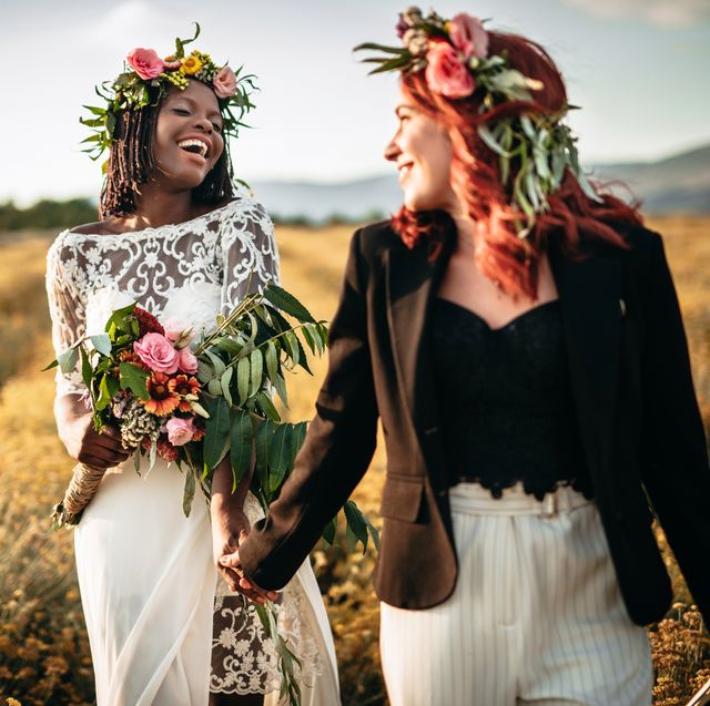 two lesbian brides walking in the flower field