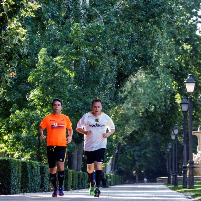 two men jogging through retiro park