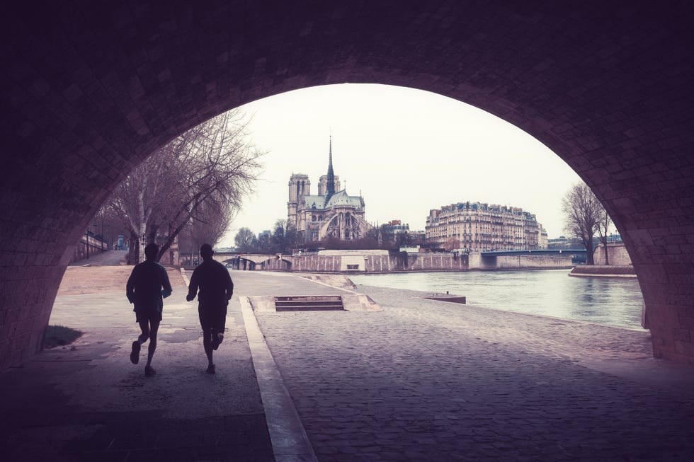 two men running with the view of note dame in day