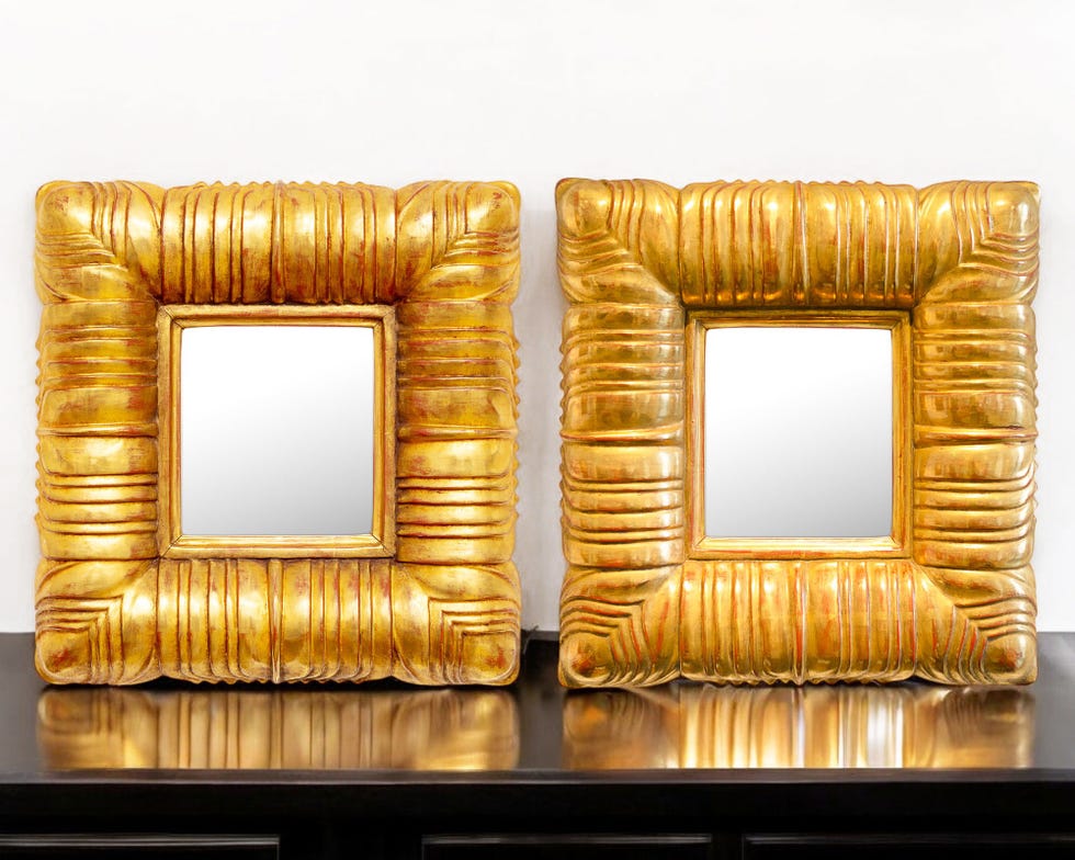 two ornate golden mirrors with square reflective surfaces set against a pale background