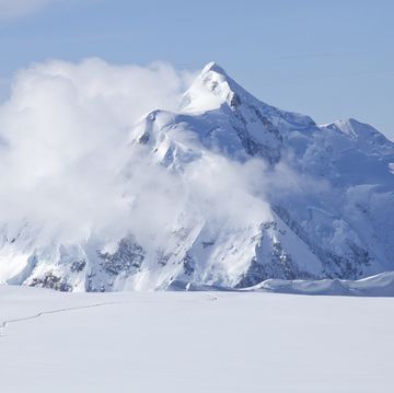 two mountaineers are crossing a glacier on mt mckinley, alaska mount hunter is in the background