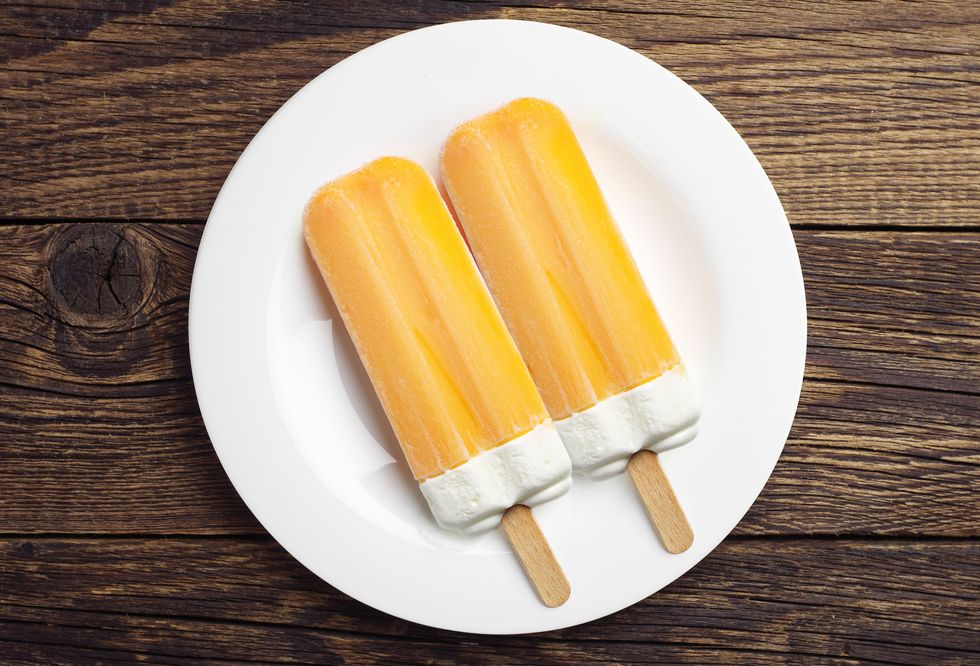 two orange popsicle in a plate